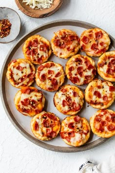 mini pizzas with cheese and pepperoni on a plate next to other food items