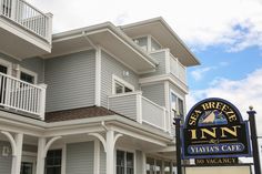 an inn sign is shown in front of a building with balconies on it