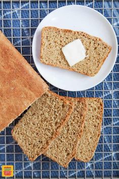 slices of bread and butter on a white plate next to a cooling rack with blue cloth