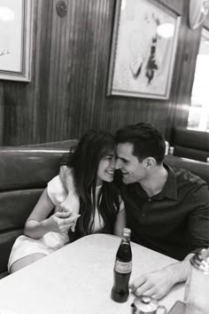 a man and woman sitting next to each other at a table