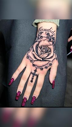 a woman's hand with tattoos and roses on it