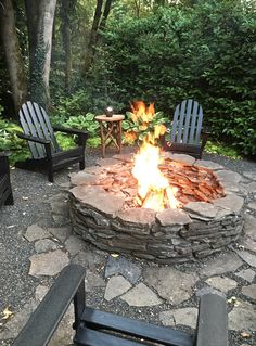 an outdoor fire pit with chairs around it