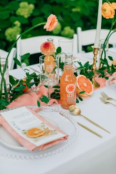 the table is set with oranges and drinks