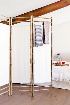 a room divider made out of bamboo sticks in the middle of a wooden floor