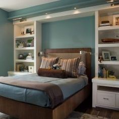 a bed room with a neatly made bed and shelves