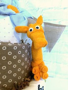 a stuffed giraffe sitting on top of a pillow