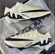 a pair of white and black shoes sitting on top of a plastic bag with the words zoom