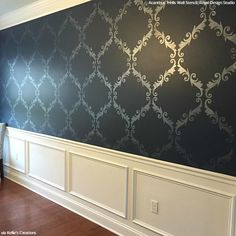 an empty room with blue wallpaper and white wains on the walls in front of a window