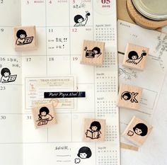 some rubber stamps are sitting on top of a calendar with children's faces drawn on them