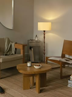 a living room filled with furniture and a lamp on top of a hard wood floor