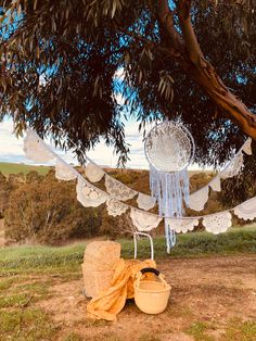 two baskets under a tree with white doily hanging from it