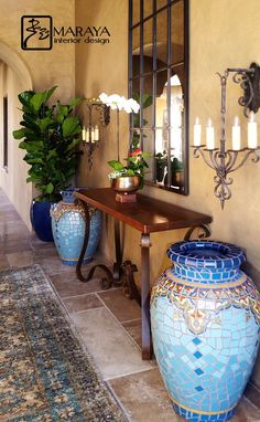 two large blue vases sitting on top of a wooden table next to a mirror