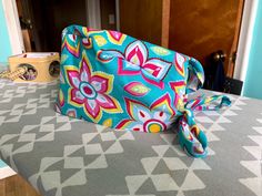 a purse sitting on top of a table covered in a blue and pink flower pattern