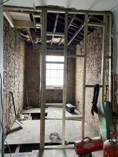 an unfinished room with exposed brick walls and windows