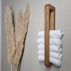 there is a towel rack with four white towels hanging on the wall next to it