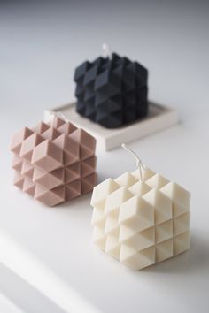 three different shapes of earrings sitting on top of a white table next to each other