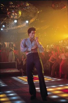 a man standing on top of a dance floor in front of a group of people