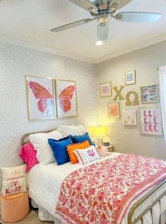 a bedroom with a bed, ceiling fan and pictures on the wall above it's headboard