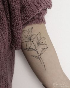 a woman's arm with a flower tattoo on the left side of her arm