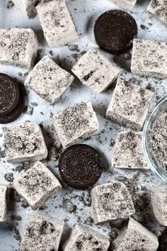 oreo cookies and marshmallows on a white surface with a glass bowl