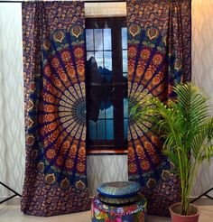 a room with a large window and colorful curtains