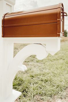 a white mailbox sitting on top of a lush green field