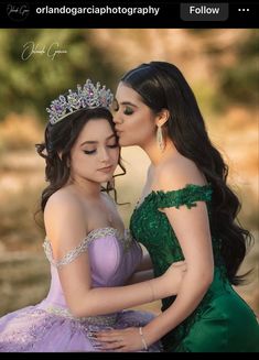 two young women dressed in dresses and tiaras, one is kissing the other's cheek