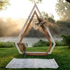 a wooden sculpture sitting on top of a lush green field