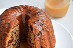 a bundt cake on a white plate with a slice cut out and ready to be eaten