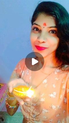 a woman in a sari holding a lit candle