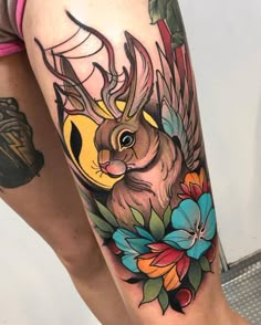 a woman's thigh with an animal and flowers tattoo on it