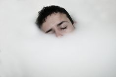 a man is in the bathtub with his eyes closed and head above the water