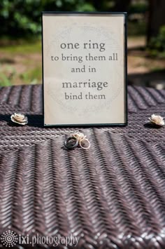 a sign that says one ring to bring them all and in marriage bind them on top of a table