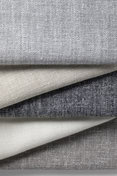 four different colors of fabric on top of each other, including grey and white linen