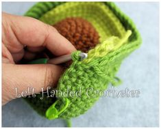 someone is crocheting an object in the shape of a flower with green leaves