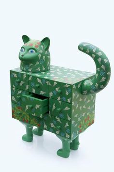 a green cat shaped box sitting on top of a white floor next to a drawer