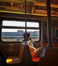 a woman sitting on a bus looking out the window