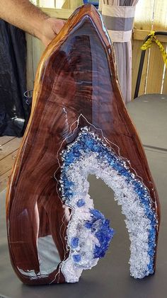 a large piece of wood with blue and white designs on it's sides, sitting on a table