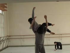 two young men doing acrobatic tricks in a dance studio