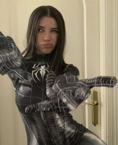 a woman in a spider - man costume is holding her hands out to the side