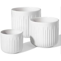 three white vases sitting next to each other