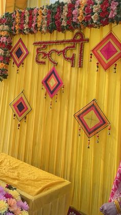 a man standing next to a bed in front of a yellow wall with flowers on it