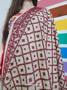 a woman wearing a red and white shawl