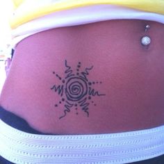 a woman's stomach with a tattoo design on the side of her belly,