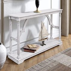 a white console table with a sailboat on it