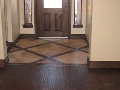 an empty entryway with wooden doors and tile flooring