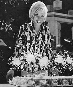 an old black and white photo of two women at a table with sparklers in front of them