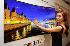 a woman standing in front of a large television screen