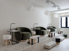 a room with several chairs and stools on the floor in front of a window