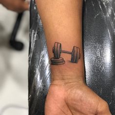 a person with a tattoo on their wrist holding a dumbble weight